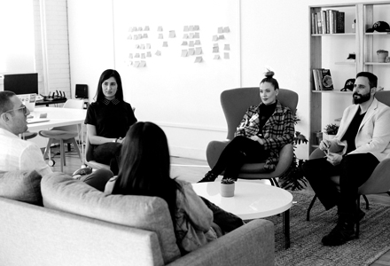 photo noir et blanc de 5 personnes en réunion de travail